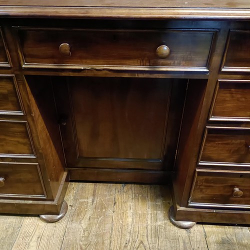 1255 - A mahogany kneehole desk, having a seven drawer configuration, with a cupboard door to kneehole, 124... 