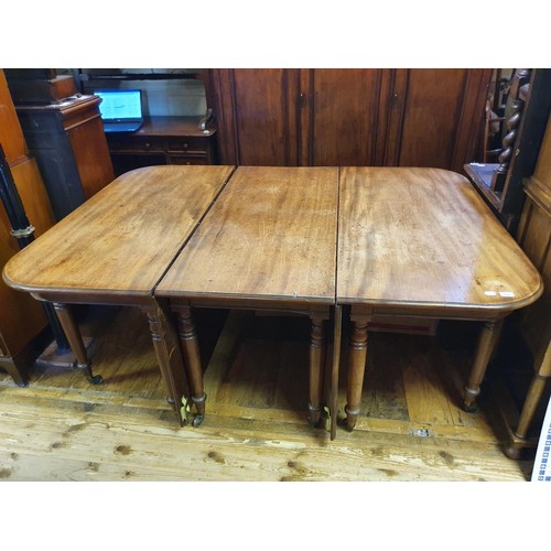 1230 - A 19th century mahogany extending dining table, the centre section with drop leaves, raising on turn... 