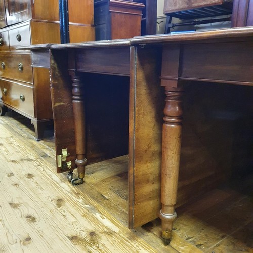 1230 - A 19th century mahogany extending dining table, the centre section with drop leaves, raising on turn... 