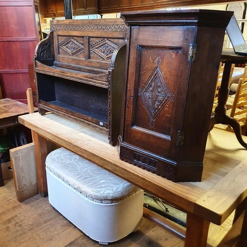 1243 - A carved oak wall hanging bookcase, a Lloyd Loom type ottoman, and an oak corner cabinet (3)