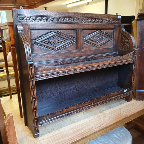 1243 - A carved oak wall hanging bookcase, a Lloyd Loom type ottoman, and an oak corner cabinet (3)