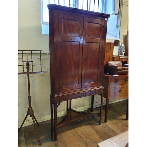 1247 - A 19th century mahogany corner cabinet, on a base on square legs united by an undertier, 104 cm wide