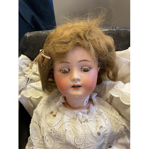 383 - A German bisque head doll, by Heubach, 250-61/2, 62 cm and two dolls prams (3)