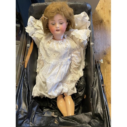 383 - A German bisque head doll, by Heubach, 250-61/2, 62 cm and two dolls prams (3)