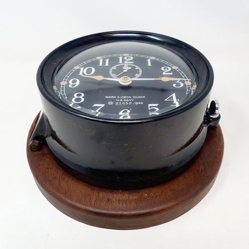 525 - A Mark I U.S. Navy Deck Clock, stamped N (within a circle) 51652, 1942, on a wooden mount, 17 cm dia... 