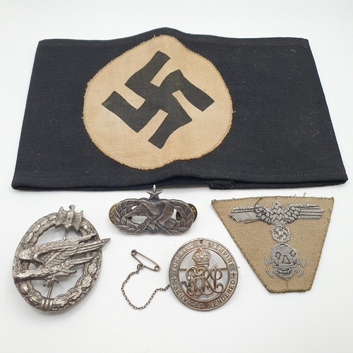 486 - A German WWII black armband, the white centre with a black swastika, a silver wound badge, RN 23477,... 