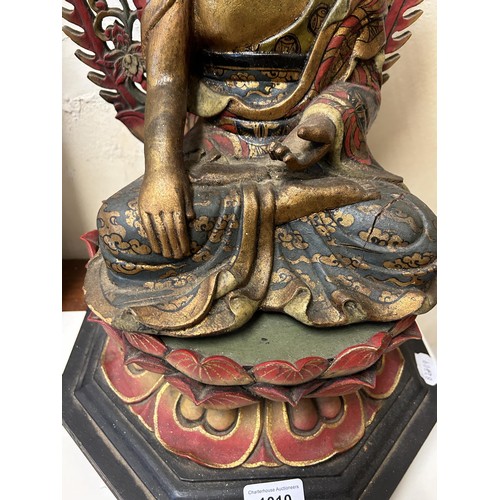 1010 - A painted and carved wooden Buddha on a stand, 50 cm high