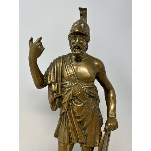 1014 - A brass figure of a Roman centurion, 30 cm high, on a later ebonised base