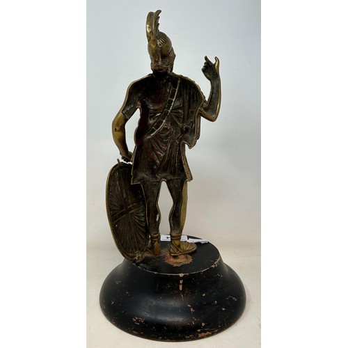 1014 - A brass figure of a Roman centurion, 30 cm high, on a later ebonised base