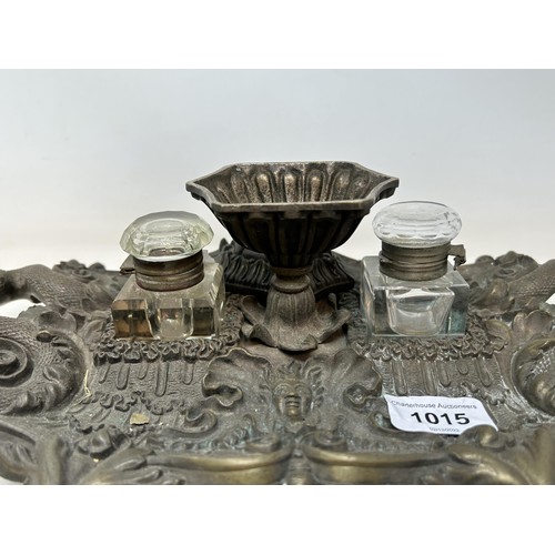 1015 - A bronze desk stand, the handles in the form of snakes, with a pair of glass inkwells