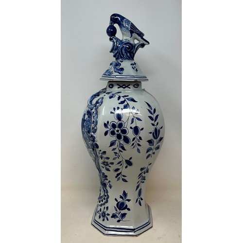 1027 - A Delft blue and white vase and cover, the finial in the form of a parrot, 45 cm high