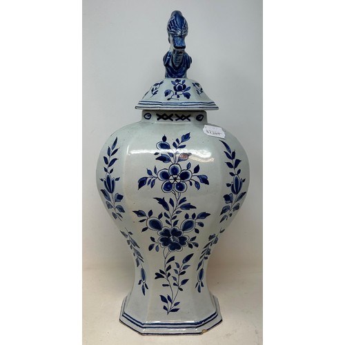 1027 - A Delft blue and white vase and cover, the finial in the form of a parrot, 45 cm high