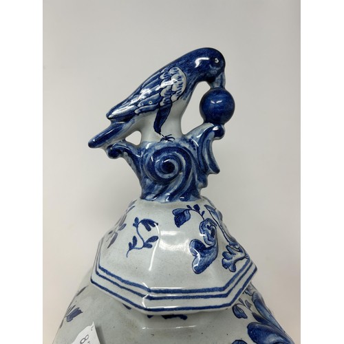 1027 - A Delft blue and white vase and cover, the finial in the form of a parrot, 45 cm high