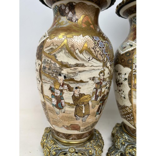 1036 - A pair of Satsuma vases, converted to oil lamps, with brass mounts, and glass chimneys, 64 cm high