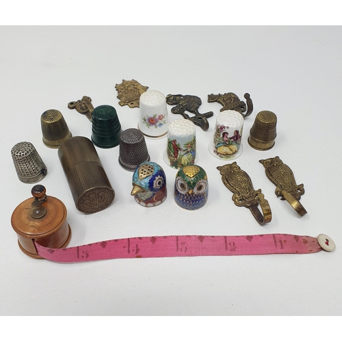 766 - A miniature tape measure, in the style of a fishing reel, and assorted thimbles (qty)