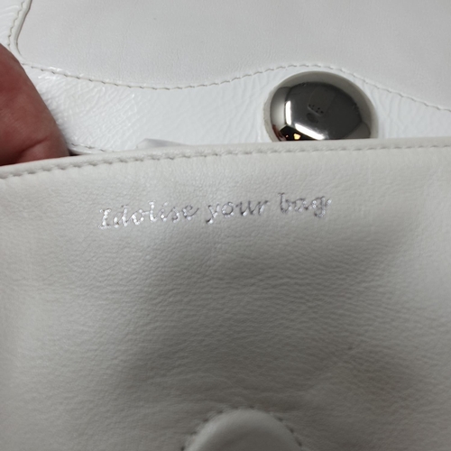 677 - A Jaeger of London white leather handbag and cover, a Ri2K black leather handbag and cover, a Ri2K w... 