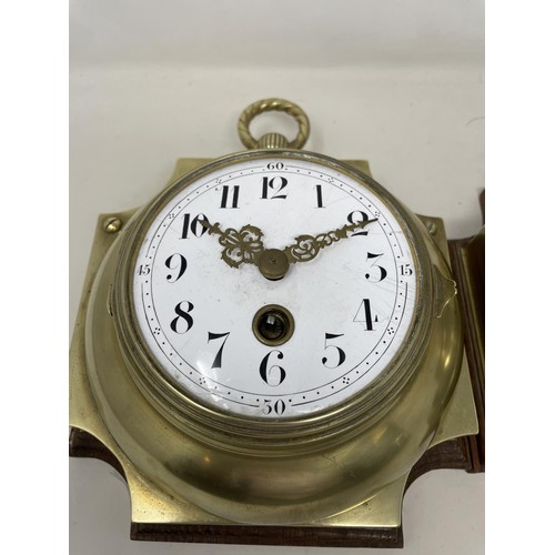 656 - A wall clock, the 11 cm diameter enamel dial with Arabic numerals, in a brass case mounted on an oak... 