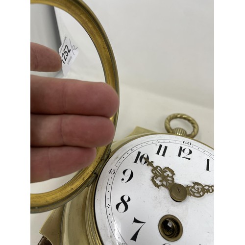 656 - A wall clock, the 11 cm diameter enamel dial with Arabic numerals, in a brass case mounted on an oak... 