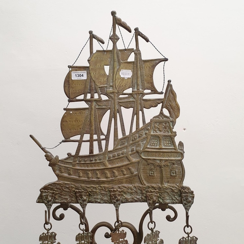 884 - An unusual Dutch brass fireside companion set, the stand with a finial in the form of a three masted... 