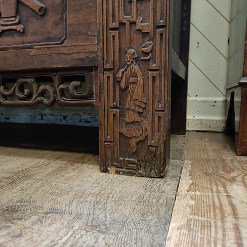 863 - A Chinese two door wardrobe, carved a town scene with figures, 170 cm high x 131 cm wide