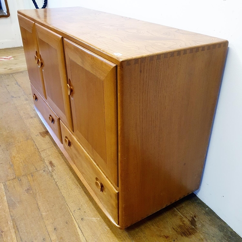 8 - An Ercol light elm sideboard, having three cupboard doors and two drawers, on castors, 132 cm wide