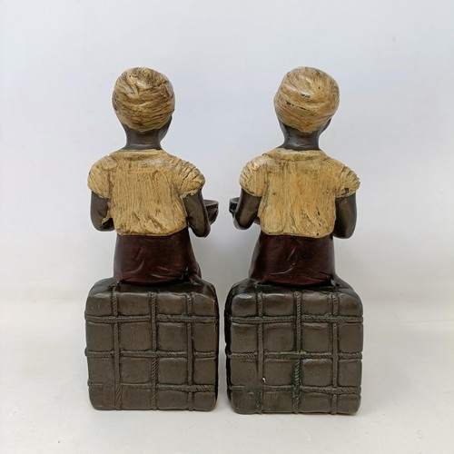 606 - A pair of cold painted bronze salts, in the form of eastern boys, 20 cm high (2)