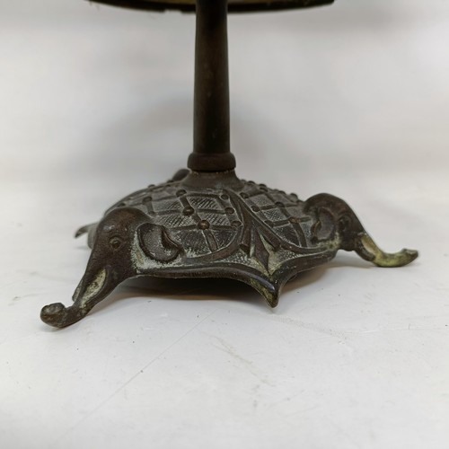 663 - A bronze two branch candelabrum, the finial in the form of a monkey, 29 cm high