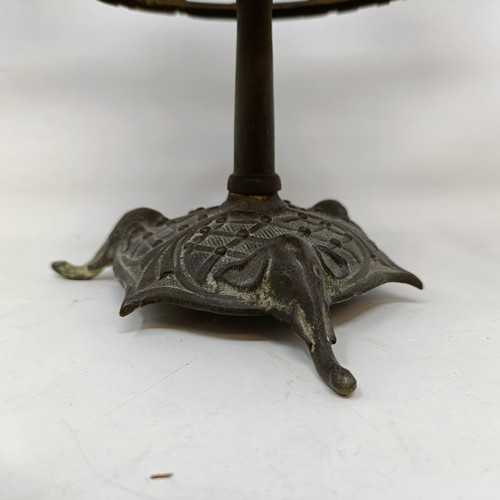 663 - A bronze two branch candelabrum, the finial in the form of a monkey, 29 cm high