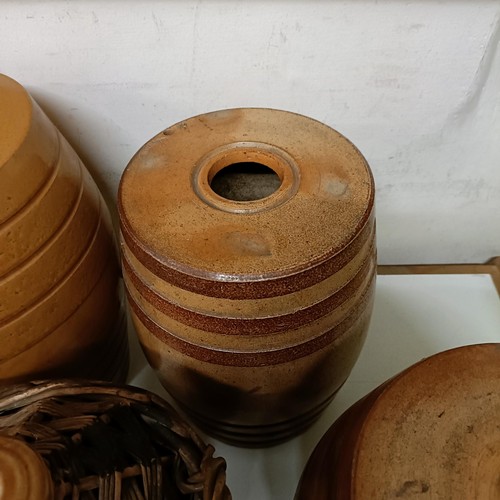 686 - A Doulton Lambeth stoneware barrel, 31 cm high, two other barrels, a storage jar, and a wicker cover... 