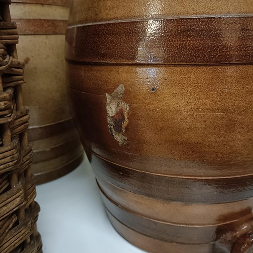 686 - A Doulton Lambeth stoneware barrel, 31 cm high, two other barrels, a storage jar, and a wicker cover... 