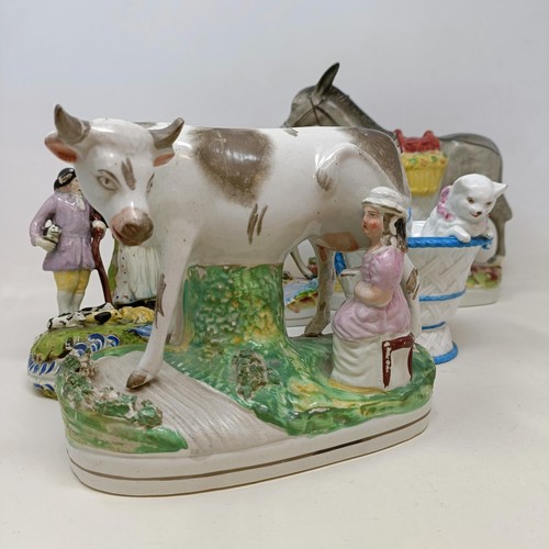 701 - A 19th century Staffordshire figure, of a donkey, 23 cm high, another, 16 cm high, a cow, a figural ... 