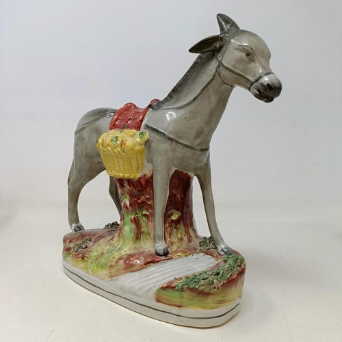 701 - A 19th century Staffordshire figure, of a donkey, 23 cm high, another, 16 cm high, a cow, a figural ... 