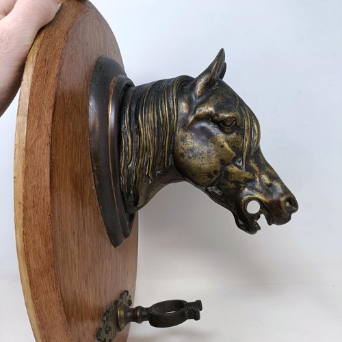 710 - A brass and stained wood wall mounted crop stand, in the form of a horse, 36 cm