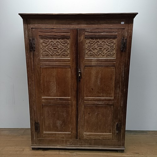 29 - An oak wardrobe with carved doors, 122 cm wide (2)