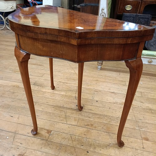 970 - A walnut serpentine folding card table, 85 cm wide