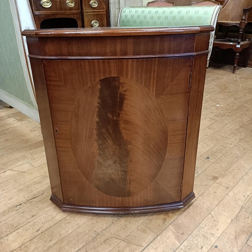 972 - A mahogany serpentine sideboard, 122 cm wide, two bedroom mirrors, a corner cabinet, and five chairs... 