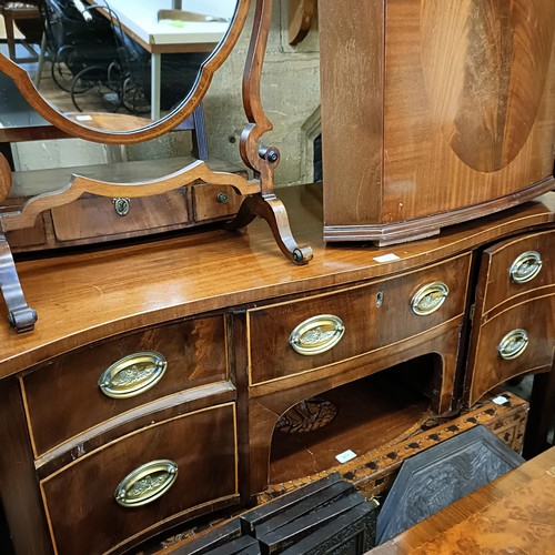 972 - A mahogany serpentine sideboard, 122 cm wide, two bedroom mirrors, a corner cabinet, and five chairs... 