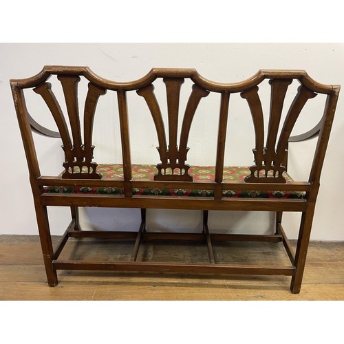 874 - An early 20th century child's mahogany three seater settee, with a pierced carved back, decorated fl... 