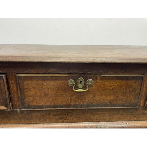 873 - A George III oak dresser base, having three drawers, 178 cm wide