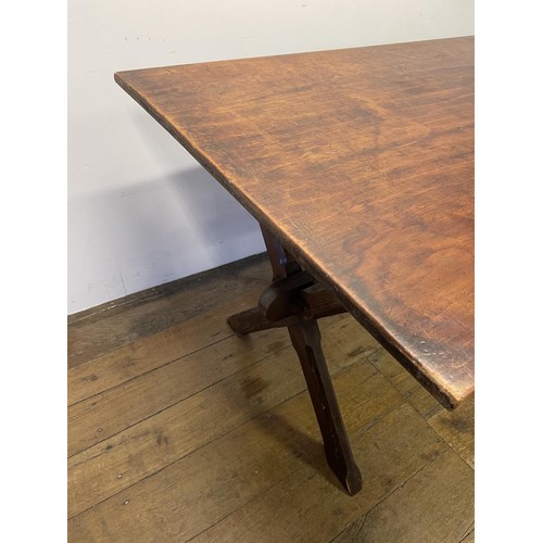 910 - A tavern table, the pine X framed support united by a stretcher, 150 cm wide