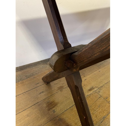 910 - A tavern table, the pine X framed support united by a stretcher, 150 cm wide