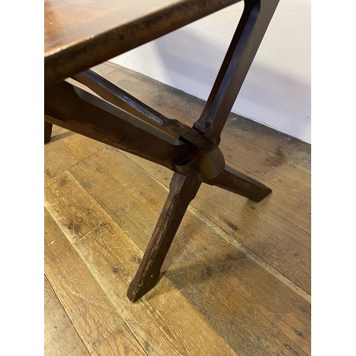 910 - A tavern table, the pine X framed support united by a stretcher, 150 cm wide