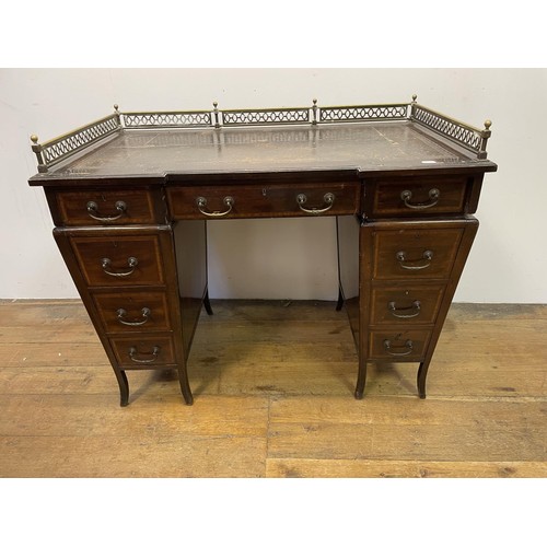 907 - An Edwardian mahogany pedestal desk, the top with a brass gallery above nine drawers, with satinwood... 