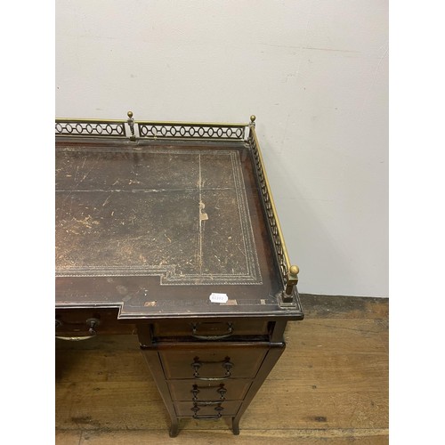 907 - An Edwardian mahogany pedestal desk, the top with a brass gallery above nine drawers, with satinwood... 