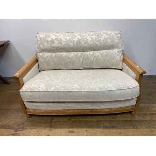 916 - An Ercol cream two seater sofa, and a matching armchair (2)