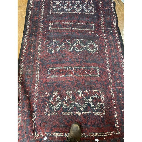 987 - A red ground Persian carpet, the centre with three rectangular medallions, 228 x 137 cm