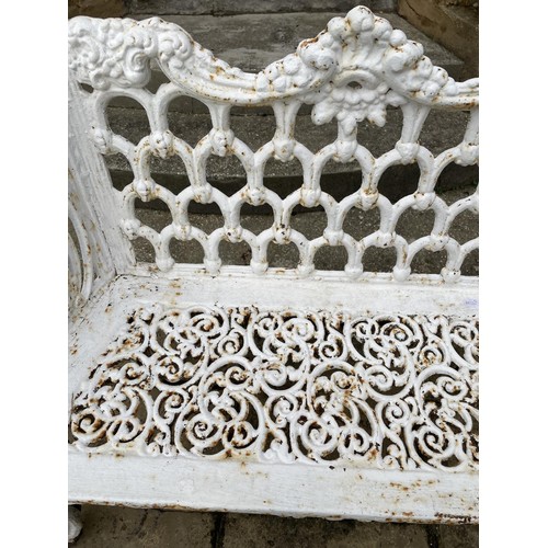 1009 - A white painted cast iron two seater garden bench, with pierced decoration and cabriole legs, 111 cm... 