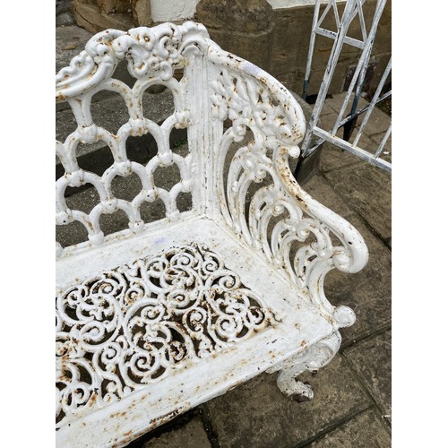 1009 - A white painted cast iron two seater garden bench, with pierced decoration and cabriole legs, 111 cm... 