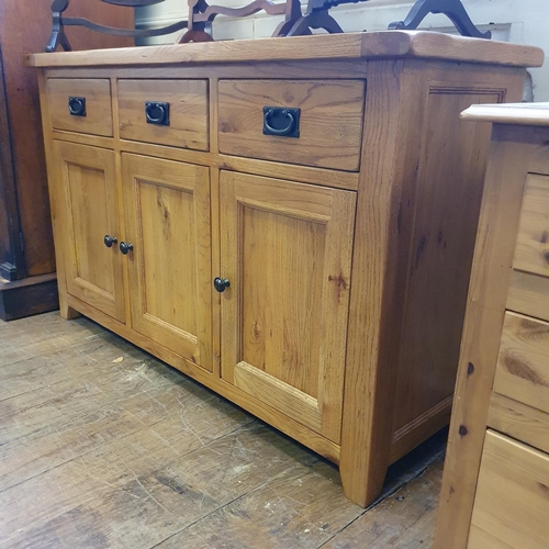 866 - A light oak sideboard, having three drawers and three cupboard doors, 141 cm wide, two chairs, three... 