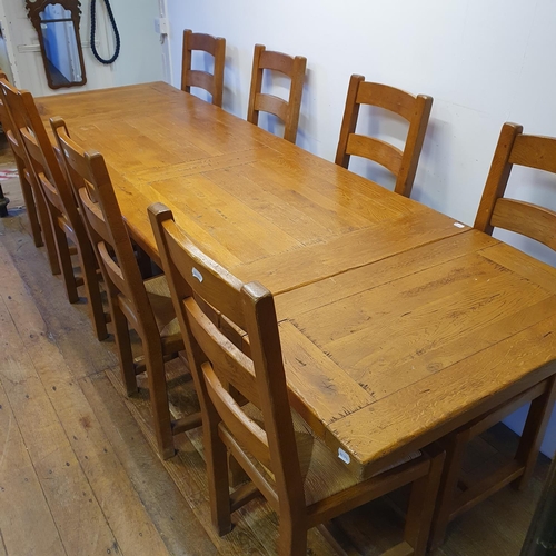 870 - An oak kitchen table, the top 180 x 87 cm, with two extra leaves, and a set of eight matching ladder... 